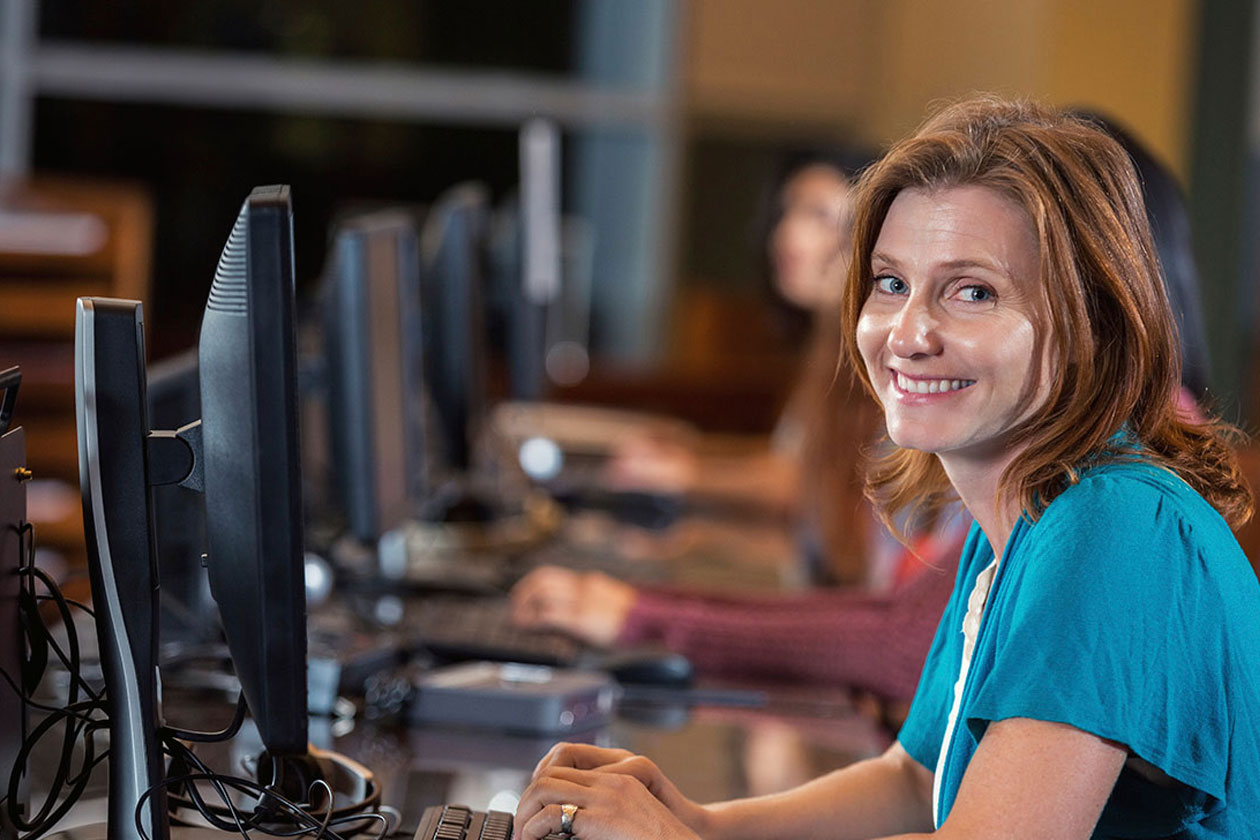 A faculty member at a computer lab workstation — the people who run academic PT programs