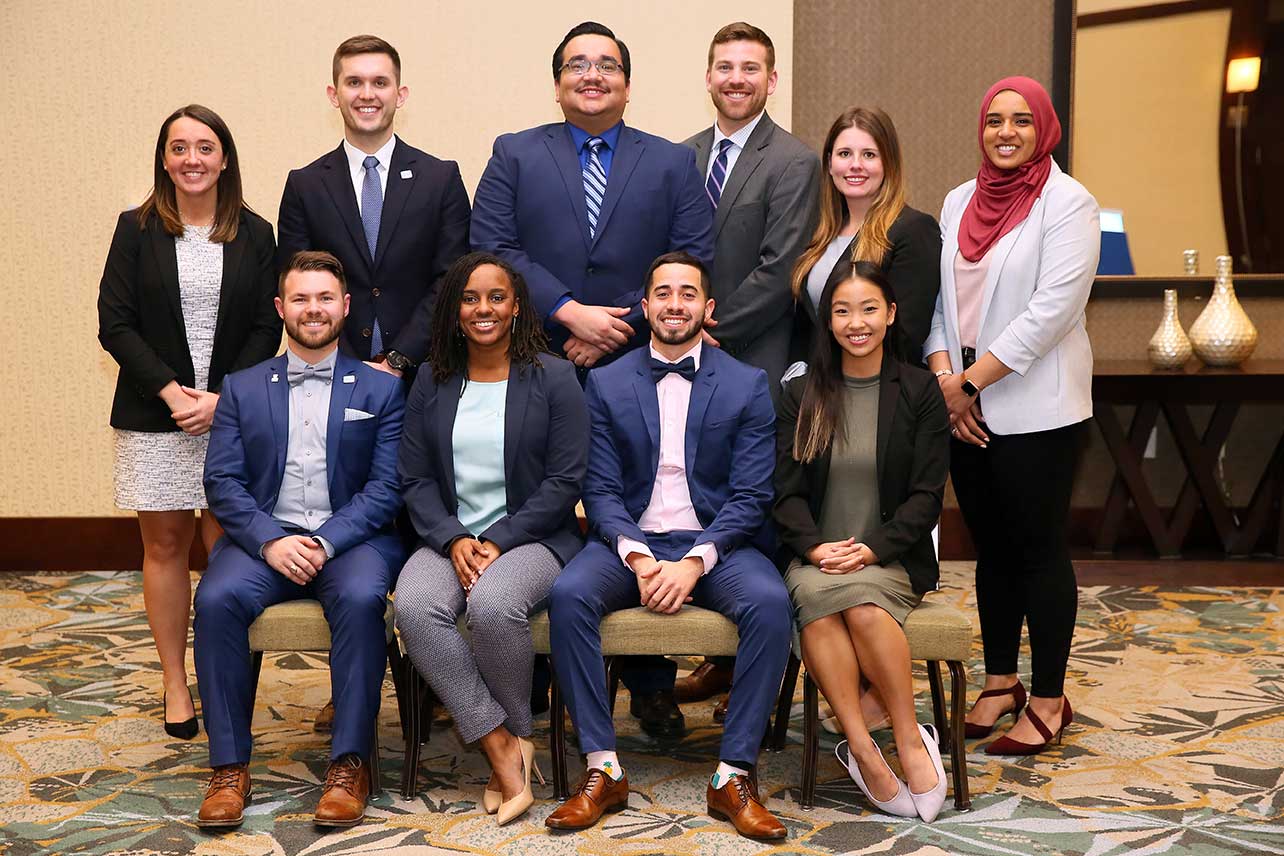 A diverse group of academic physical therapy professionals in formal attire